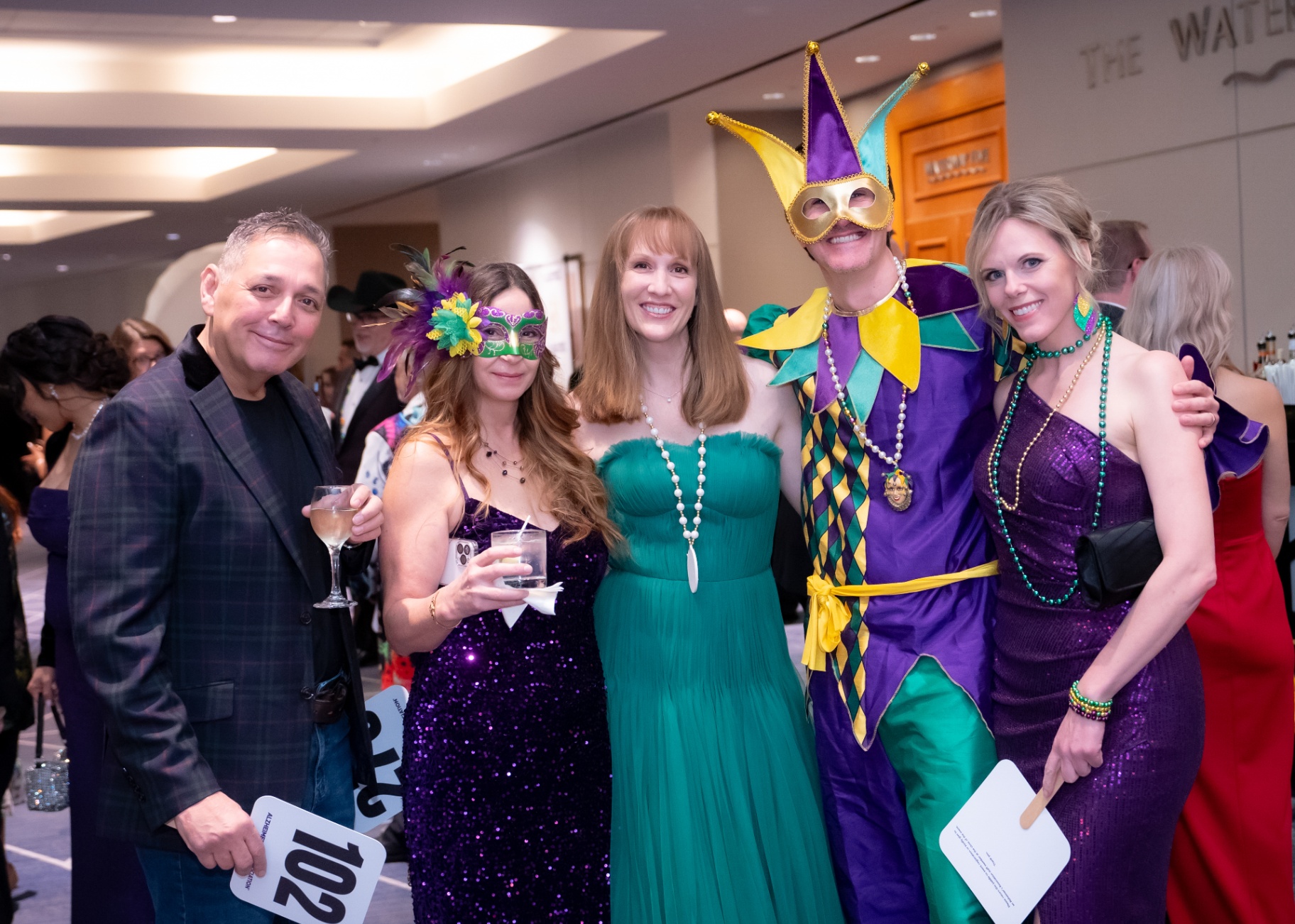 Guests in Mardi Gras attire on the gala floor